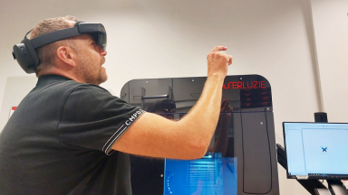 Das Bild zeigt eine Person mit einer AR-Brille, die eine Laserbeschriftungsanlage bedient.